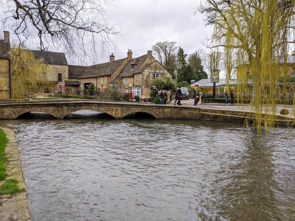 A view on a river, bridge and old cottages in Bourton on Water - visiting this village is one of the best things to do near Clarkson's Farm.