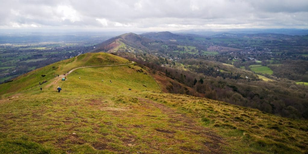 A trail at the top of the hills with views of woodlands. Malvern Hills walk, one of the best walks near the Cotswolds.