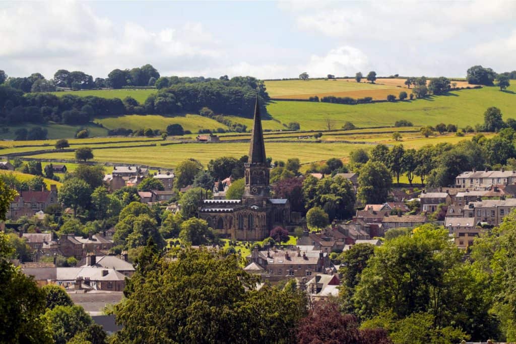 View at a town with houses, church and hills.