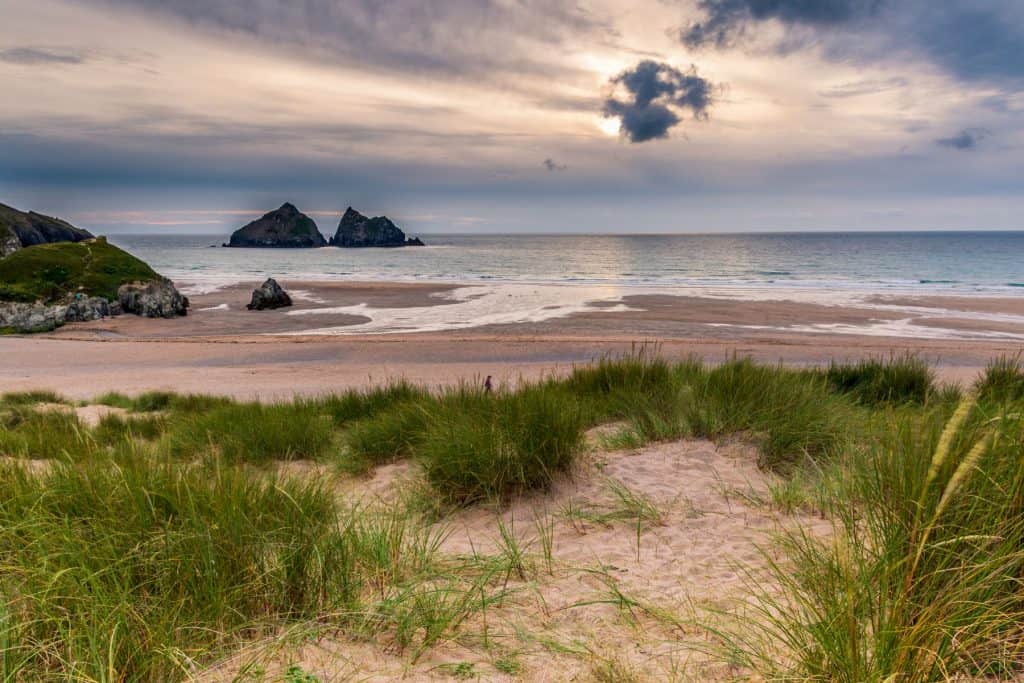 A view at the Holywell Bay beach in Cornwall with sand and cliffs at back.