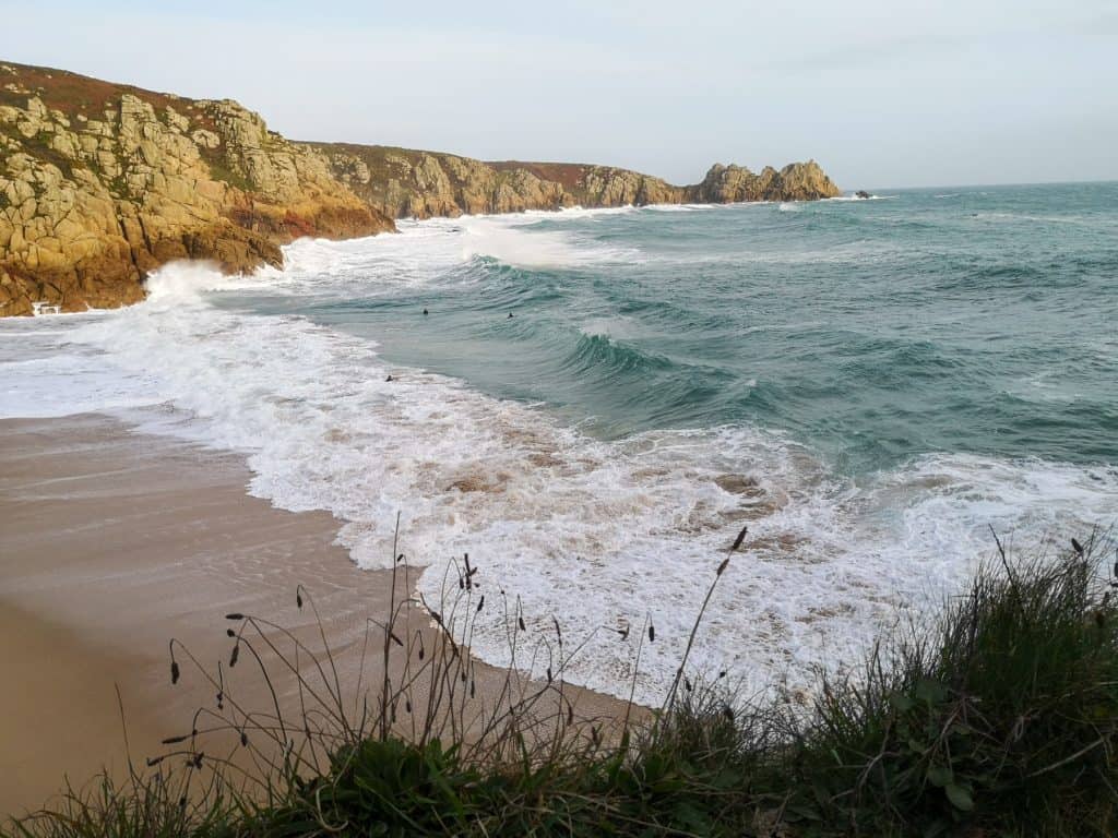 Wild blue sea near Porthcurno beach with cliffs at back, , one of the nice beaches in Cornwall.