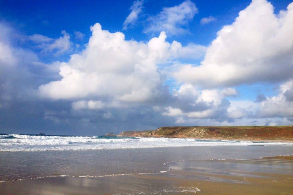 Beach with wild sea and cliffs.