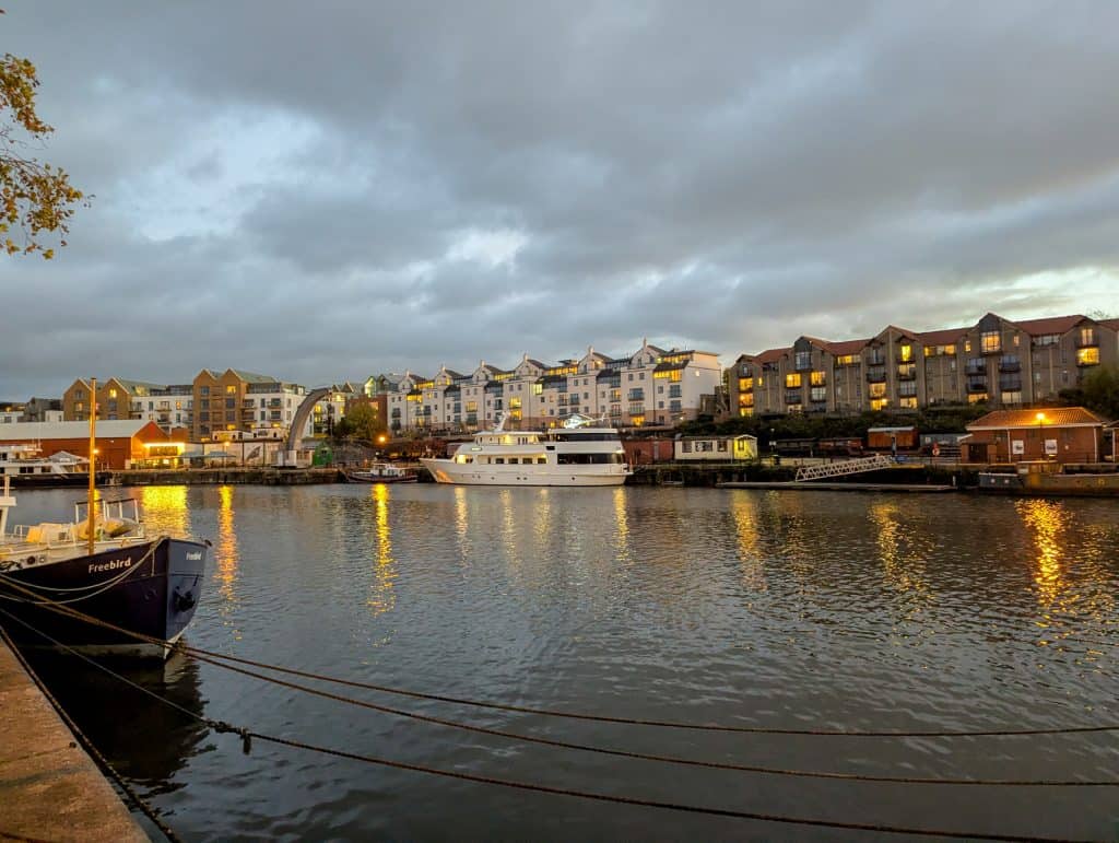 Bristol Harbour at dusk with boats and houses.
