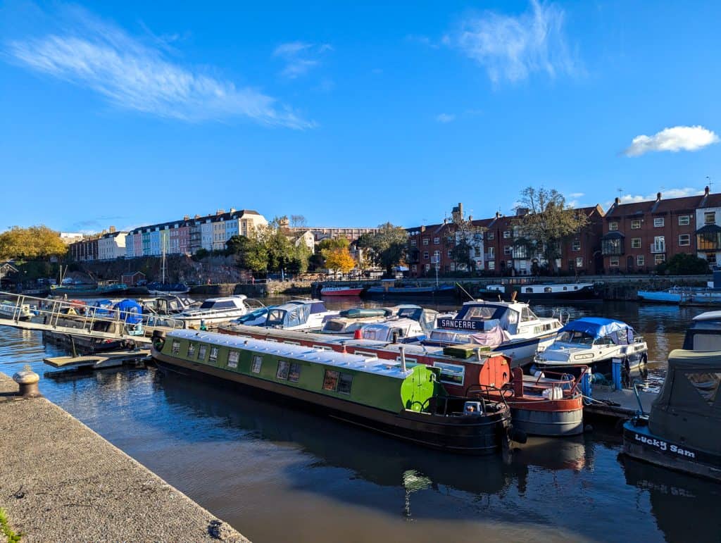 Boats in the Bristol harbour with houses at back.