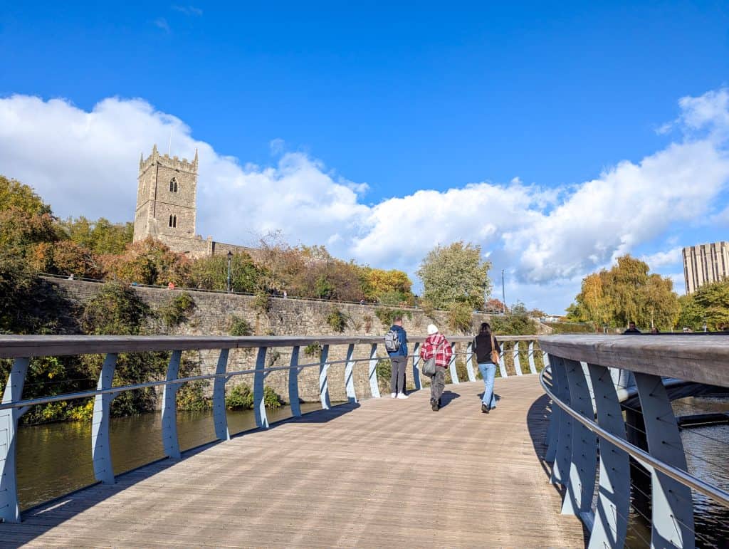 People walking across bridge in the centre of Bristol.