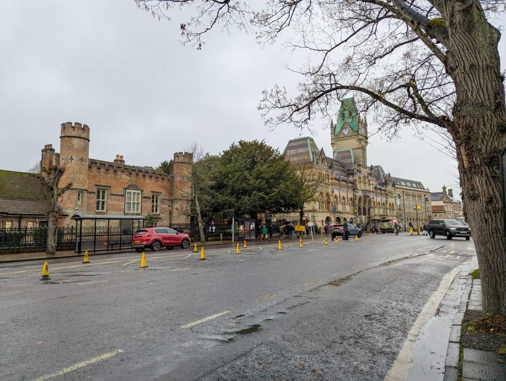 A street in Winchester with Guildhall and historical buildings and cars.