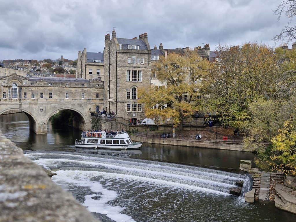 View at the river Avon with the Pulteney bridge and a boat, boat cruise is one of the best things to do in Bath for couples..