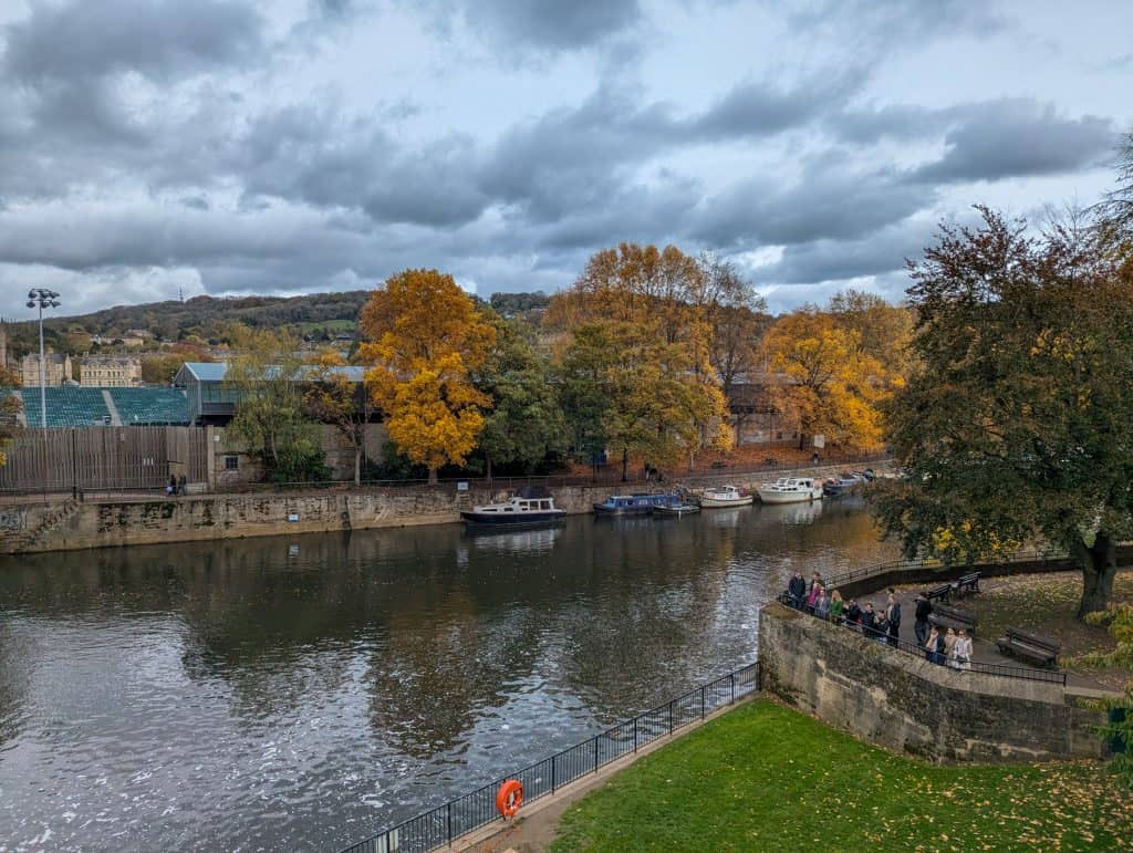 River Avon in Bath with colourful trees and cloudy weather, riverside walks is one of the best things to do in Bath for couples.