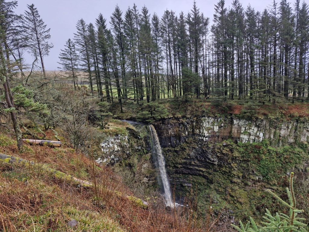 Eas Mor waterfall with a gorge from a viewing platform with trees.