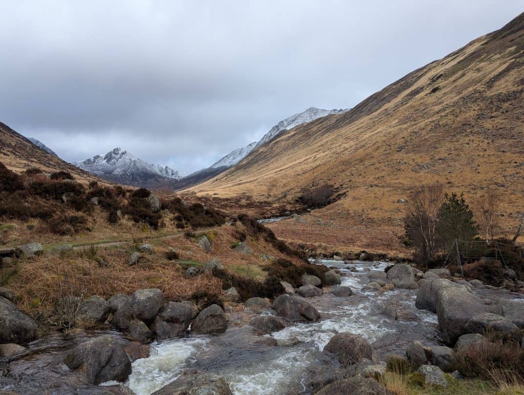 Glen Rosa, one of the most beautiful places and among the best things to do on Isle of Arran, with the river, trees and snowy mountains. 