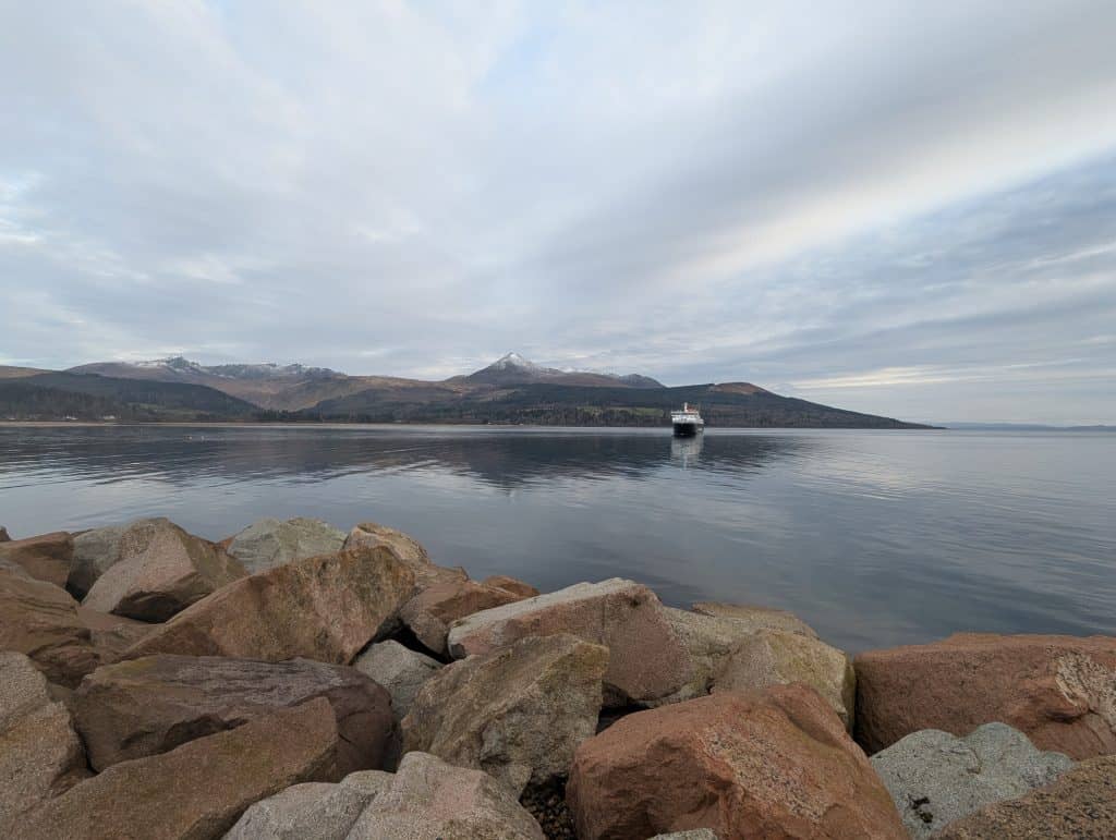Broadick with ferry boat and mountains.